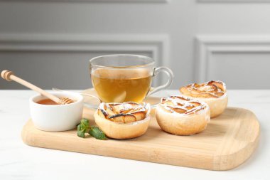 Nane, bal ve çay ile taze pişmiş elma gülleri beyaz masada.