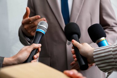 Bir grup gazeteci iş adamlarıyla içeride röportaj yapıyor, yakın çekim yapıyorlar.