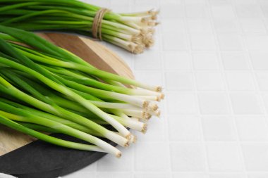 Beyaz fayanslı masada taze yeşil soğan. Metin için boşluk