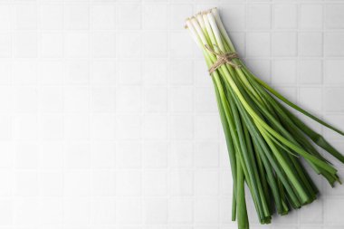 Beyaz fayanslı masada taze taze soğan, üst manzara. Metin için boşluk