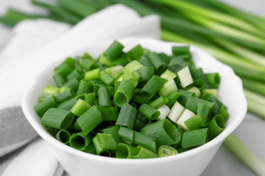 Kavanozda doğranmış yeşil soğan ve saplar masada, yakın plan.