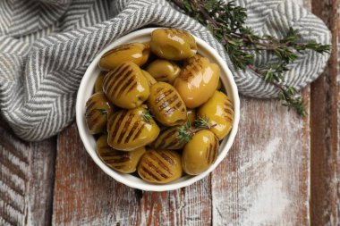 Tahta masada kekik ile ızgara yeşil zeytin, düz yatıyordu.