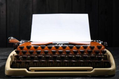 Siyah arkaplan üzerinde kağıt yaprağı olan klasik daktilo, kapat