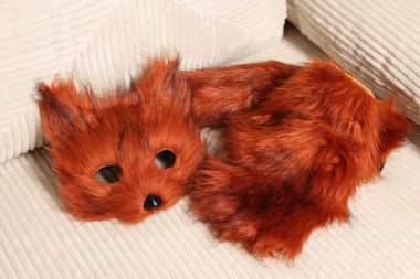 Quadrobics. Fox mask, gloves and tail on sofa clipart