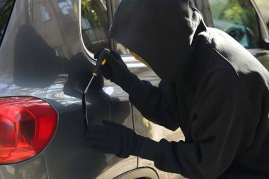 Yakıt kepini açan tornavidalı bir hırsız. Araba kaçırma.