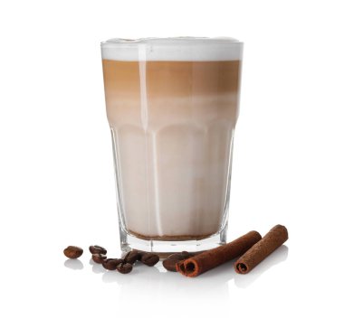Bardakta latte macchiato, beyaz kahve çekirdekleri ve tarçın.