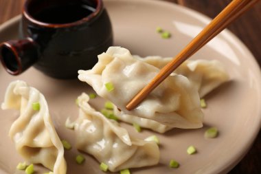 Sofrada çubuklarla lezzetli gyoza (hamur tatlısı) yemek, yakın plan.