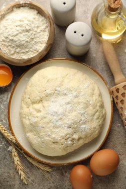 Taze hamur, malzemeler ve merdane gri masada, düz yatıyordu.