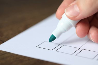 Ahşap masada kağıt kutusunu işaretleyen kadın, yakın plan.