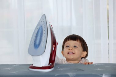 İçerideki demire bakan gülümseyen çocuk. Çocuk tehlikede.