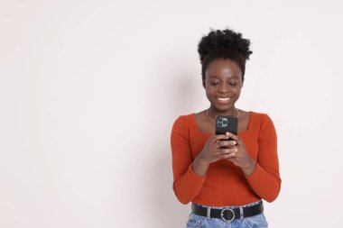Beyaz arka planda akıllı telefonu olan mutlu bir kadın. Metin için boşluk