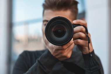 Profesyonel fotoğrafçı dışarıda kamerayla fotoğraf çekiyor, seçici odaklanma.