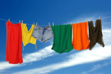 Different clothes drying on washing line against blue sky