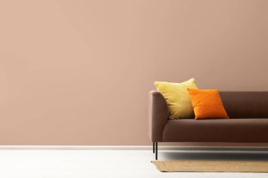 Mocha Mousse gölgesinde şık bir iç mekan. 2025 'in moda rengi kanepe ve duvar