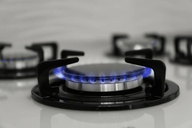 Modern sobanın gaz ocağı, yanan mavi alev, yakın çekim.