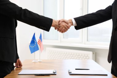 Diplomatlar toplantı sırasında el sıkışıyor, yakınlaşıyorlar.