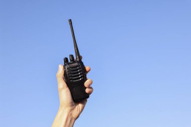 Mavi gökyüzüne karşı telsizi olan kadın, yakın plan. Metin için boşluk