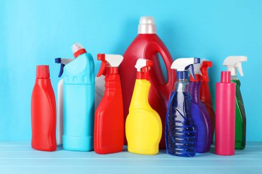 Açık mavi ahşap masada farklı temizlik ürünleri