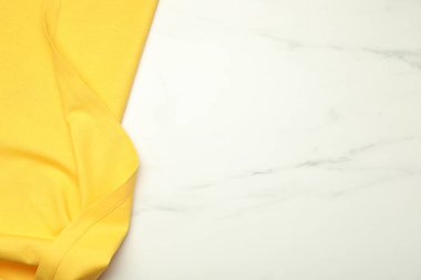 Beyaz mermer zemin üzerinde sarı masa örtüsü, üst manzara. Metin için boşluk