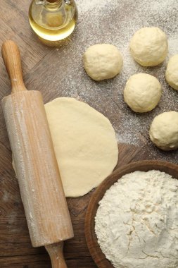 Taze hamur, merdane, un ve yağ ahşap masa, düz uzanmış