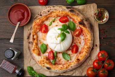 Tahta masada servis edilen burrata peyniriyle nefis bir pizza.