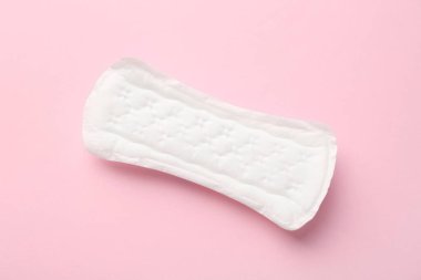 Açık pembe arka planda regl yastığı, üst görünüm