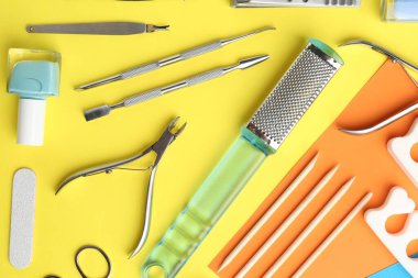 Renk arkaplanı üzerinde pedikür araçları kümesi, düz yatar