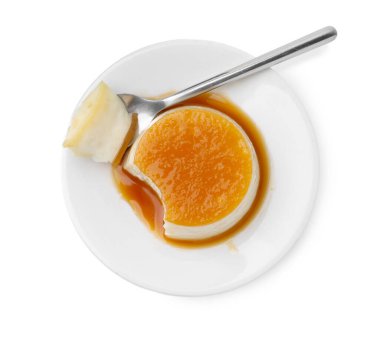 Karamel soslu lezzetli puding ve beyaza izole edilmiş kaşık.
