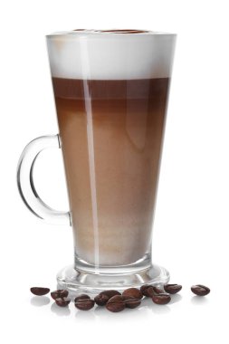 Cam bardakta latte macchiato ve beyaz kahve çekirdekleri.