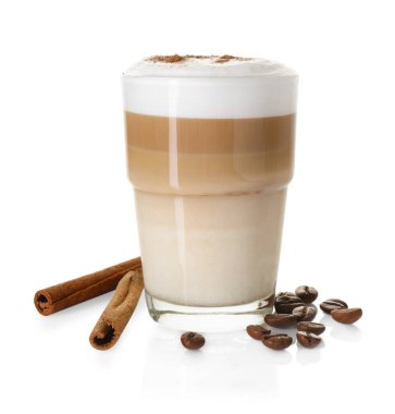 Bardakta latte macchiato, beyaz kahve çekirdekleri ve tarçın.