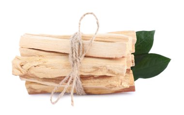 Beyaz arka planda palo santo sopaları ve yeşil yapraklar.