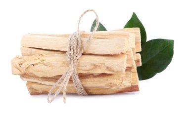Beyaz arka planda palo santo sopaları ve yeşil yapraklar.