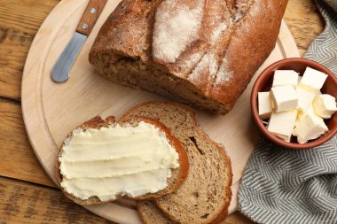 Tahta masada tereyağı ve bıçak ile taze ekmek, düz yatıyordu.
