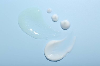 Açık mavi arkaplanda krema ve jel örnekleri, üst görünüm