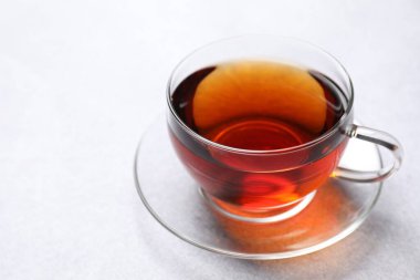 Aromatik siyah çay bardakta, aydınlık masada, yakın plan. Metin için boşluk