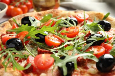Domatesli, zeytinli ve roka soslu lezzetli pizza.