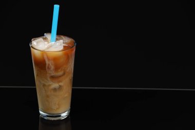 Siyah ayna yüzeyinde sütlü buzlu kahveyi tazeliyorum. Metin için boşluk