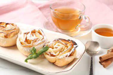 Nane, bal, tarçın çubukları ve beyaz mermer masada çay ile taze pişmiş elma gülleri, yakın plan.