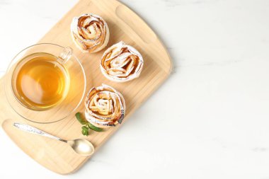 Nane şekerli taze elmalı güller ve beyaz mermer masada çay, üst manzara.