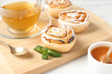 Nane, bal ve çay ile taze pişmiş elma gülleri beyaz masada, yakın plan.