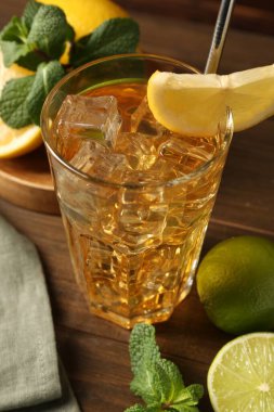 Buzlu çayı limon dilimi, kireç ve nane şekeri ile ahşap masada tazeliyorum. Yakın plan.