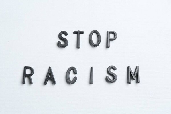 Фраза Stop Racism на светло-сером фоне, вид сверху