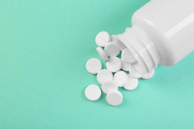 Turkuaz arka planda bir şişe antibiyotik hapı. Metin için boşluk