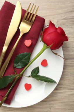 Ahşap masasında kırmızı gül olan romantik bir yer. Sevgililer Günü kutlaması