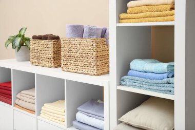 Katlanmış çarşaflar, havlular ve yastıklar içerideki raf ünitesinde. Ev tekstil deposu
