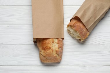 Beyaz ahşap masa üzerinde taze baget torbaları, üst manzara.