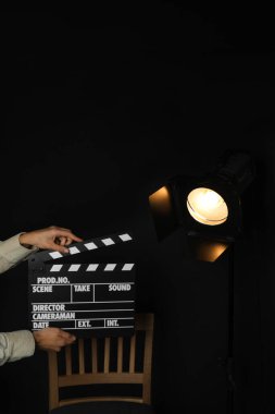 Siyah arka planda spot ışıkları olan kadın, yakın plan.