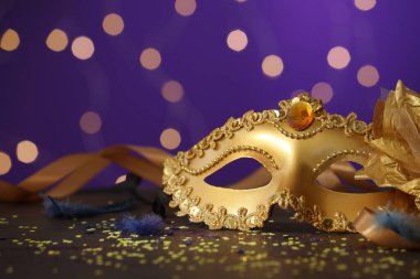 Renkli arka planda güzel bir karnaval maskesi, kurdeleler ve konfeti, bulanık ışıklar, yakın plan