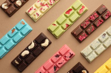 Bej arka planda farklı lezzetli çikolatalar, düz yatış.