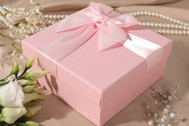 Güzel düğün hediyesi, çiçekler ve inci mücevherler ipek kumaşta, yakın plan.